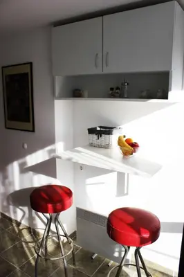 a kitchen with two red stools and a white counter at Bankya Guest House - Sofia in Bankya