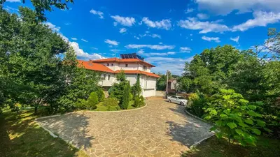 a house with a car parked in the driveway at Guest House Au Nature in Golyama Zhelyazna