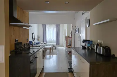 a kitchen with a counter and a living room at Red Door Apartment in Sofia