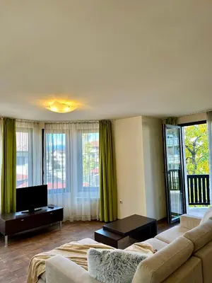 a living room with a couch and a tv at House Laudis in Bansko
