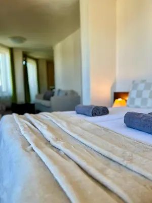 a large bed with two blue pillows on it at House Laudis in Bansko