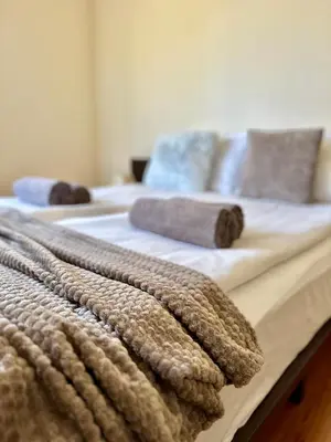 two beds with towels on top of them in a bedroom at House Laudis in Bansko