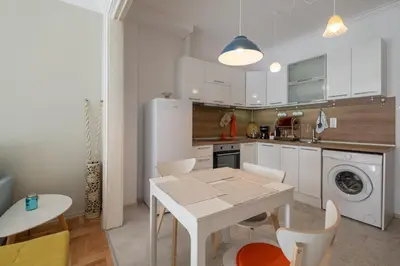 a kitchen with a table and a white refrigerator at Two Bedroom Apartment Near to Doctors Garden in Sofia