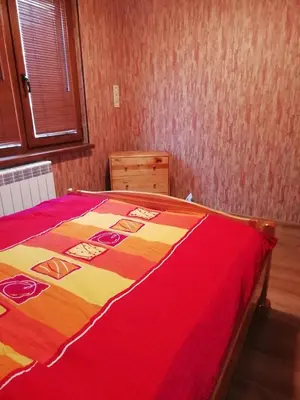 a bedroom with a bed with a red and yellow blanket at Apartment Lagera 55 in Sofia