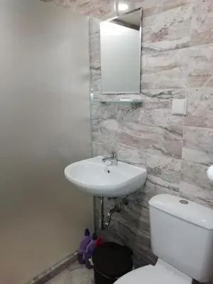 a bathroom with a sink and a toilet and a mirror at Apartment Lagera 55 in Sofia