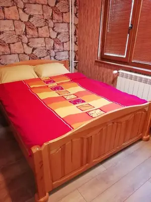 a large bed in a room with a stone wall at Apartment Lagera 55 in Sofia
