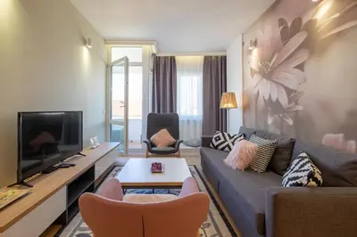 a living room with a couch and a tv at Vitosha Blvd Luxury 2-Bedroom, 2-Bathroom with Balcony in Sofia