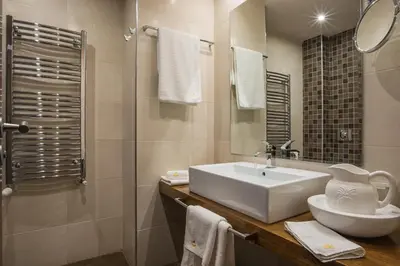 a white bathroom with a sink and a shower at Boutique Hotel Uniqato in Bansko