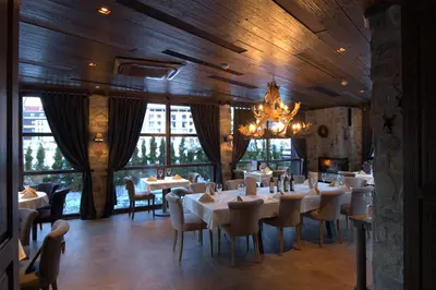 a dining room with tables and chairs and a chandelier at Boutique Hotel Uniqato in Bansko