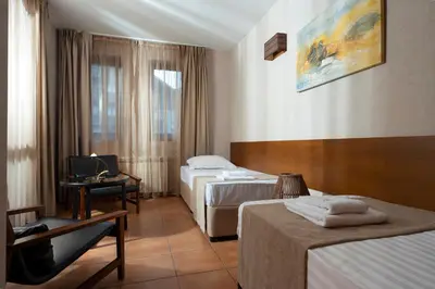 a hotel room with two beds and a television at Boutique Hotel Uniqato in Bansko