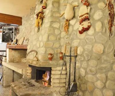 a stone wall with a fireplace in a kitchen at Hotel Dumanov in Bansko