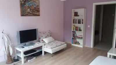 a living room with a tv and a couch and a table at Cosy place close to the Center in Sofia