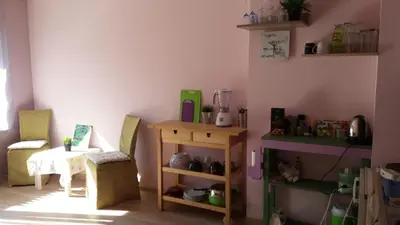 a room with a table and a chair and a shelf at Cosy place close to the Center in Sofia