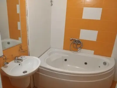 a bathroom with a white tub and a sink at ХОТЕЛ НИК in Asenovgrad