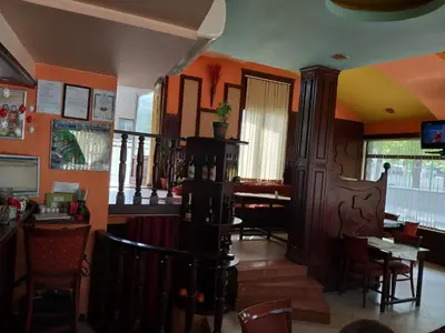 a restaurant with orange walls and a table and chairs at ХОТЕЛ НИК in Asenovgrad