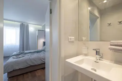 a bathroom with a sink and a bed at Vitosha Blvd 3-Bedroom, 2-Bathroom Lux Suite in Sofia