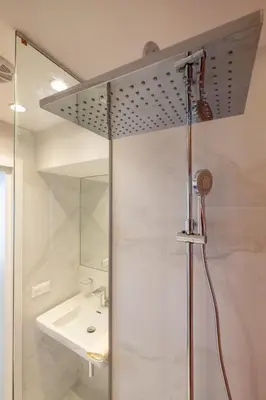 a shower in a bathroom with a sink at Vitosha Blvd 3-Bedroom, 2-Bathroom Lux Suite in Sofia