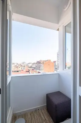 an empty room with a window with a stool at Vitosha Blvd 3-Bedroom, 2-Bathroom Lux Suite in Sofia