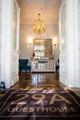 a hallway with a chandelier and a rug on the floor at 29A Guesthouse in Plovdiv