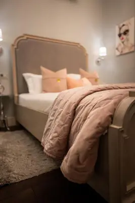 a bedroom with a bed with pink and white pillows at 29A Guesthouse in Plovdiv