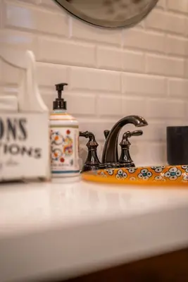 a sink with a faucet and a bottle of soap at 29A Guesthouse in Plovdiv