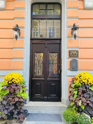 a black door on a house with two flowers at 29A Guesthouse in Plovdiv