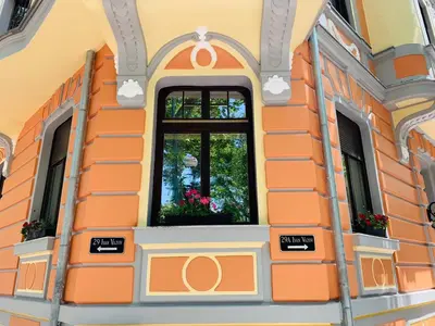 an orange building with a window with flowers in it at 29A Guesthouse in Plovdiv