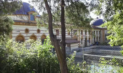 a large building with a fence in front of it at Red House in Kyustendil