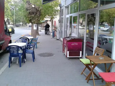 a sidewalk with tables and chairs on a street at Apartment Sagittarius in Kyustendil