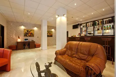 a living room with a leather couch and a bar at Hotel Cheap - Smart choice - Great value in Sofia