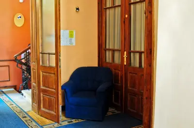 a blue chair sitting in a hallway next to a door at L'Opera Guest House in Sofia