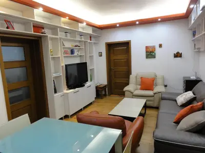 a living room with a couch and a tv at Apartment SOFIA LUX TOP CENTER in Sofia