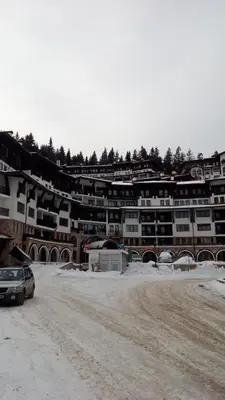 a car parked on a dirt road in front of a building at Grand Monastery - Studio Rossa in Pamporovo
