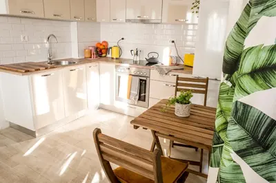 a kitchen with a wooden table and a sink at Baba Taki Apartment in Plovdiv