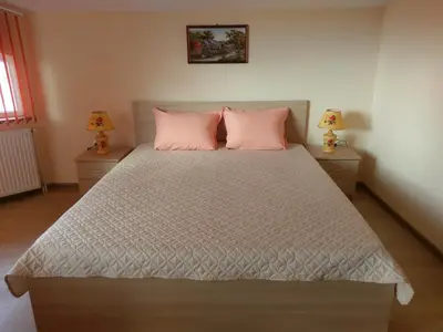 a bedroom with a large bed with pink pillows at Стаи за гости Елени in Shiroki Dol