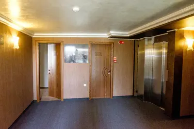 an empty hallway with three elevators in a building at Hotel Elit in Pernik