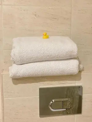 a stack of towels in a bathroom with a rubber duck at Agora Studios in Plovdiv