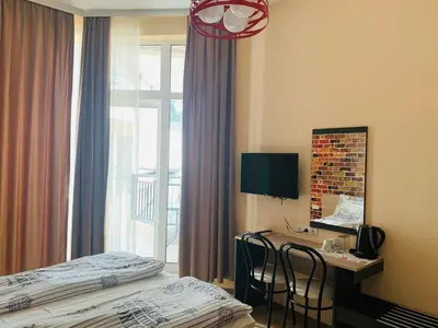 a hotel room with a bed and a desk and a window at Agora Studios in Plovdiv