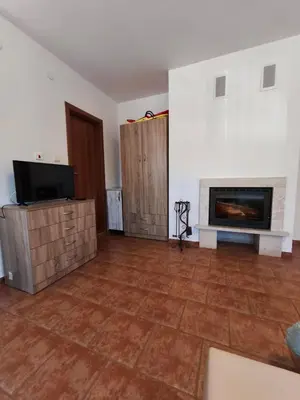 a living room with a fireplace and a tv at the old inn in Bansko