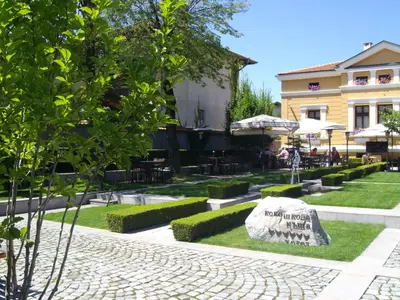 a garden with a rock in front of a building at Kokoshkovata Boutique House in Samokov