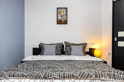 a bedroom with a bed with a black and white comforter at Roof top terrace maisonette in Plovdiv