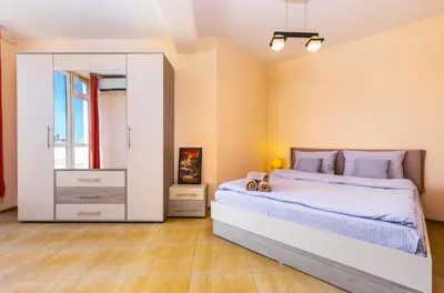 a bedroom with a large bed and a mirror at Roof top terrace maisonette in Plovdiv