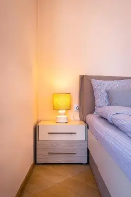a nightstand with a lamp on it next to a bed at Roof top terrace maisonette in Plovdiv