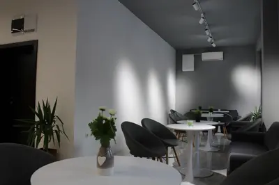 a waiting room with tables and chairs and plants at Hotel39 in Plovdiv