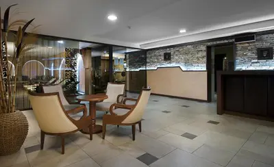 a lobby with chairs and a table and a bar at Apartments Bansko in Bansko