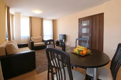 a living room with a table with a bowl of fruit on it at Apartments Bansko in Bansko