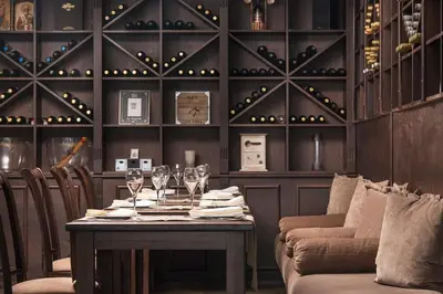 a dining room with a table with wine glasses at Apartments Bansko in Bansko