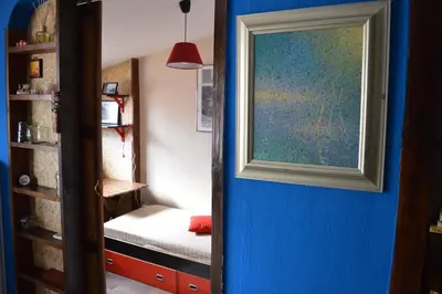 a door leading to a room with a bed and a painting at Mansard Art Studio - Central Sofia in Sofia