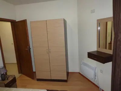 a large wooden cabinet in a room with a mirror at Ski & Holiday Apartments in Pamporovo in Pamporovo
