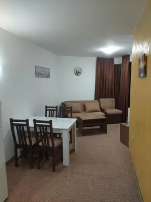 a living room with a table and chairs and a couch at Ski & Holiday Apartments in Pamporovo in Pamporovo